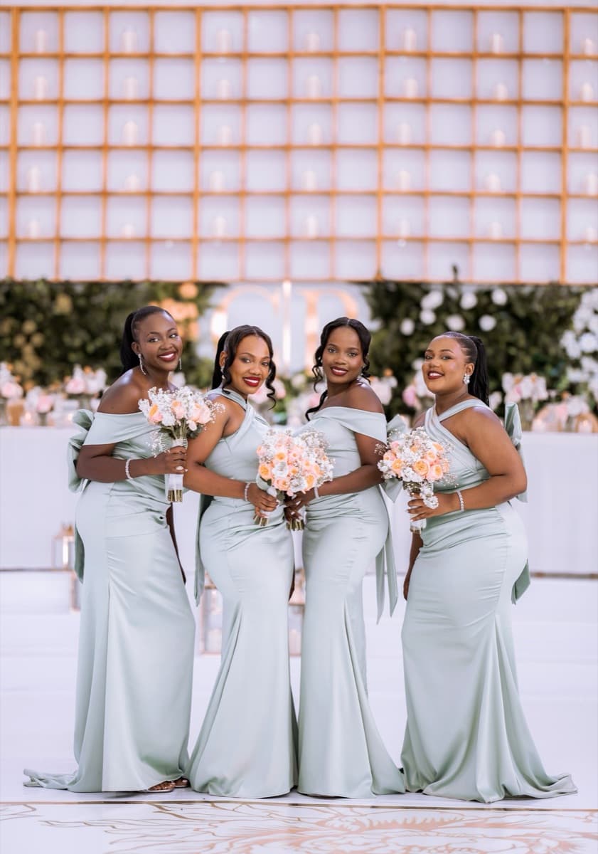 Bridesmaids in sage green gowns with peach bouquets